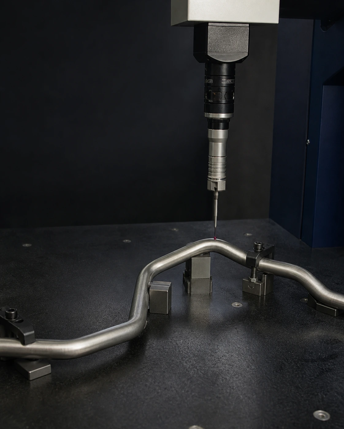 Single continuous stainless steel seat-frame tube secured on a granite metrology table beneath a CMM ruby touch probe